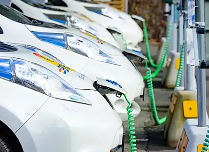 row of electric cars in charge